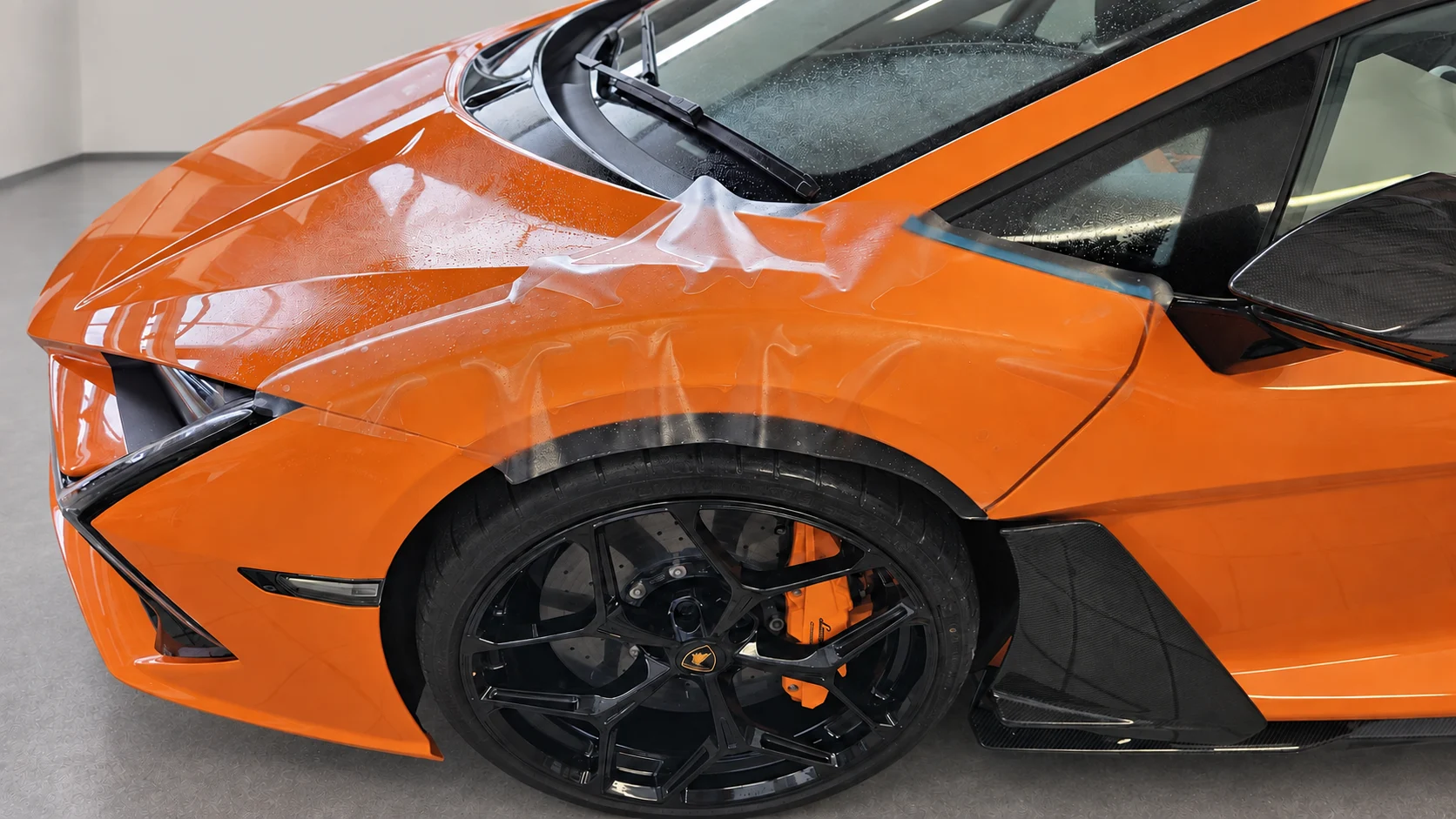 PPF plėvelės formavimas ant oranžinio Lamborghini Revuelto detalės